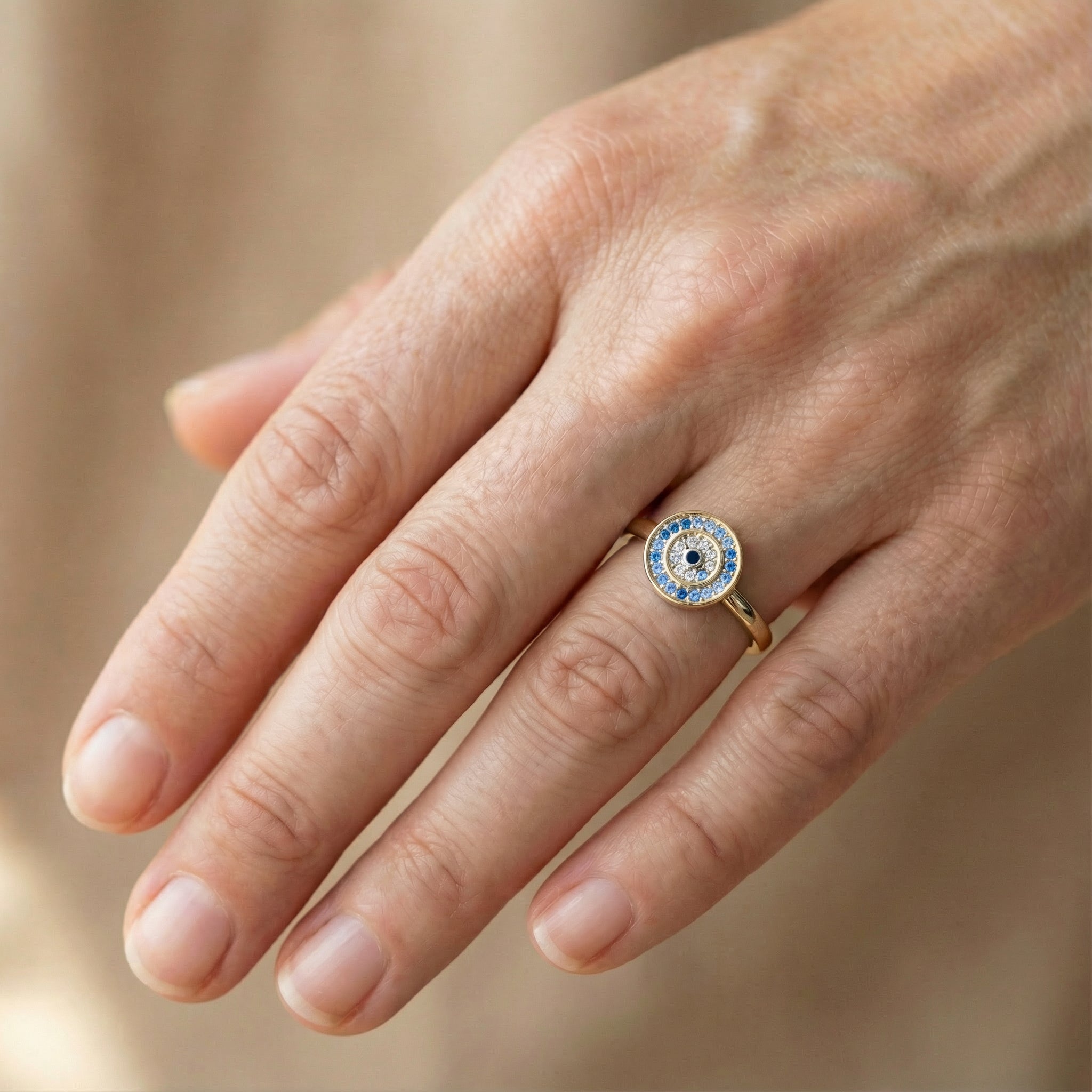 Bague dorée rotative Onde Azur Holiseeds portée à la main, rendu réaliste du bijou.