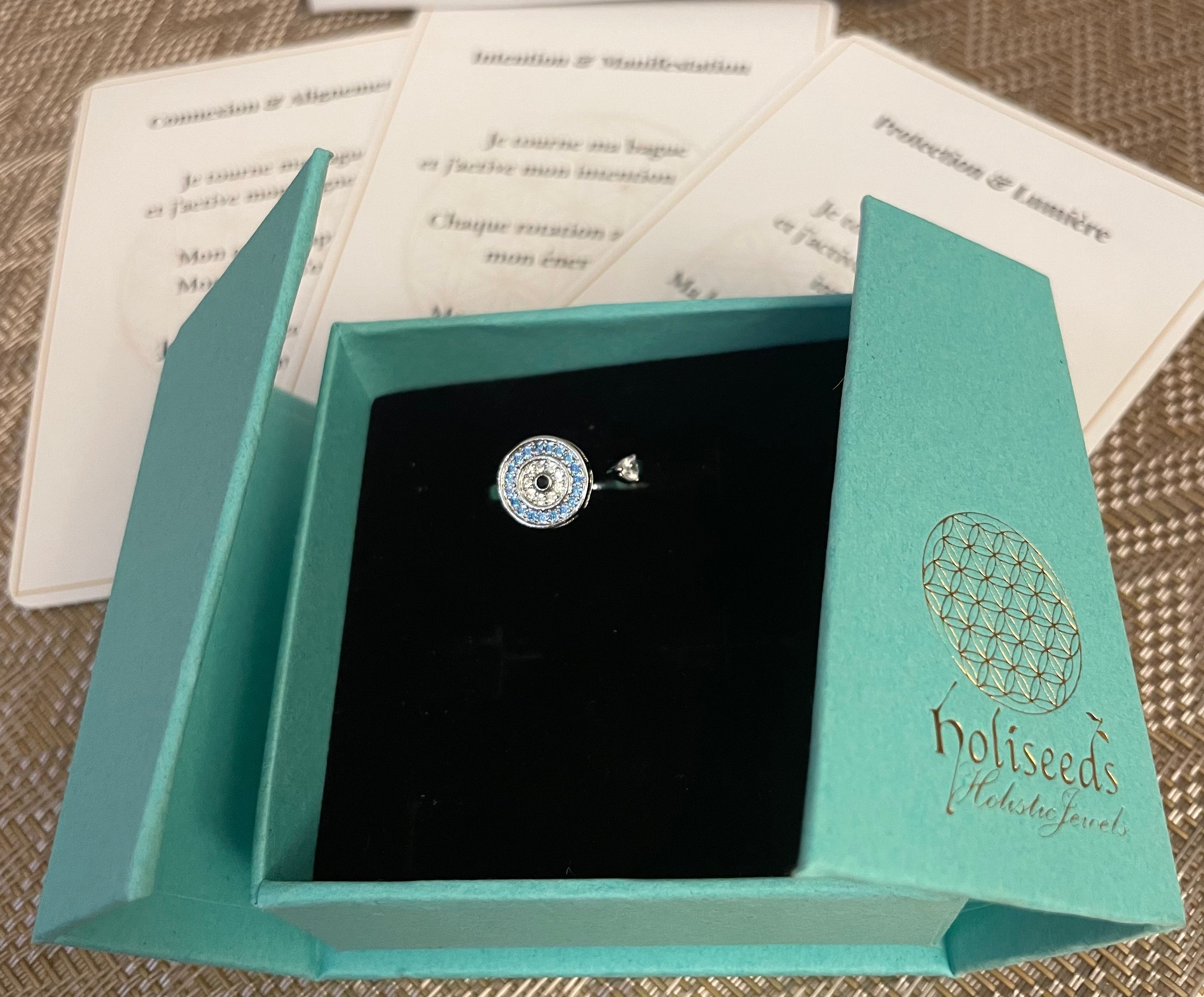 Bague argentée Onde Azur Holiseeds présentée dans son écrin, avec cartes mantra de la marque.