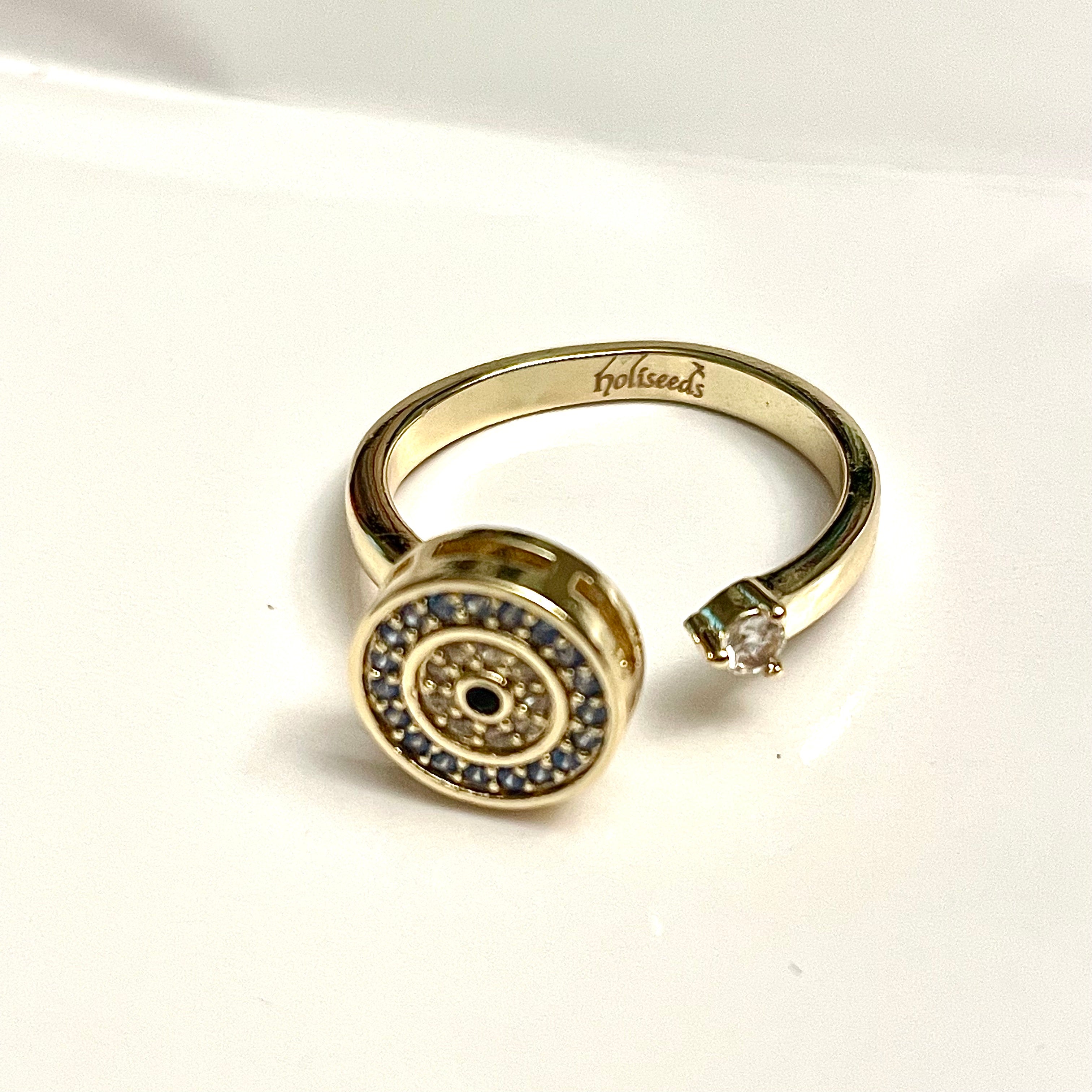 Bague dorée rotative Onde Azur Holiseeds – vue macro du motif circulaire et des pierres.