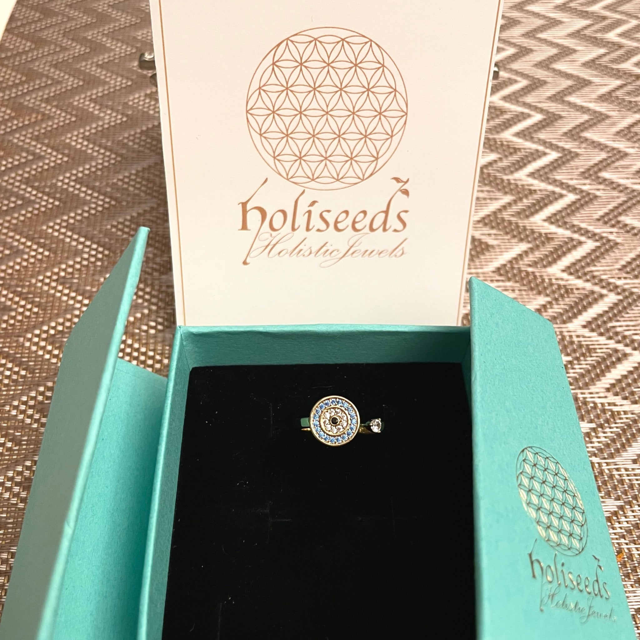 Bague Onde Azur dorée Holiseeds présentée dans son écrin turquoise avec cartes mantra.