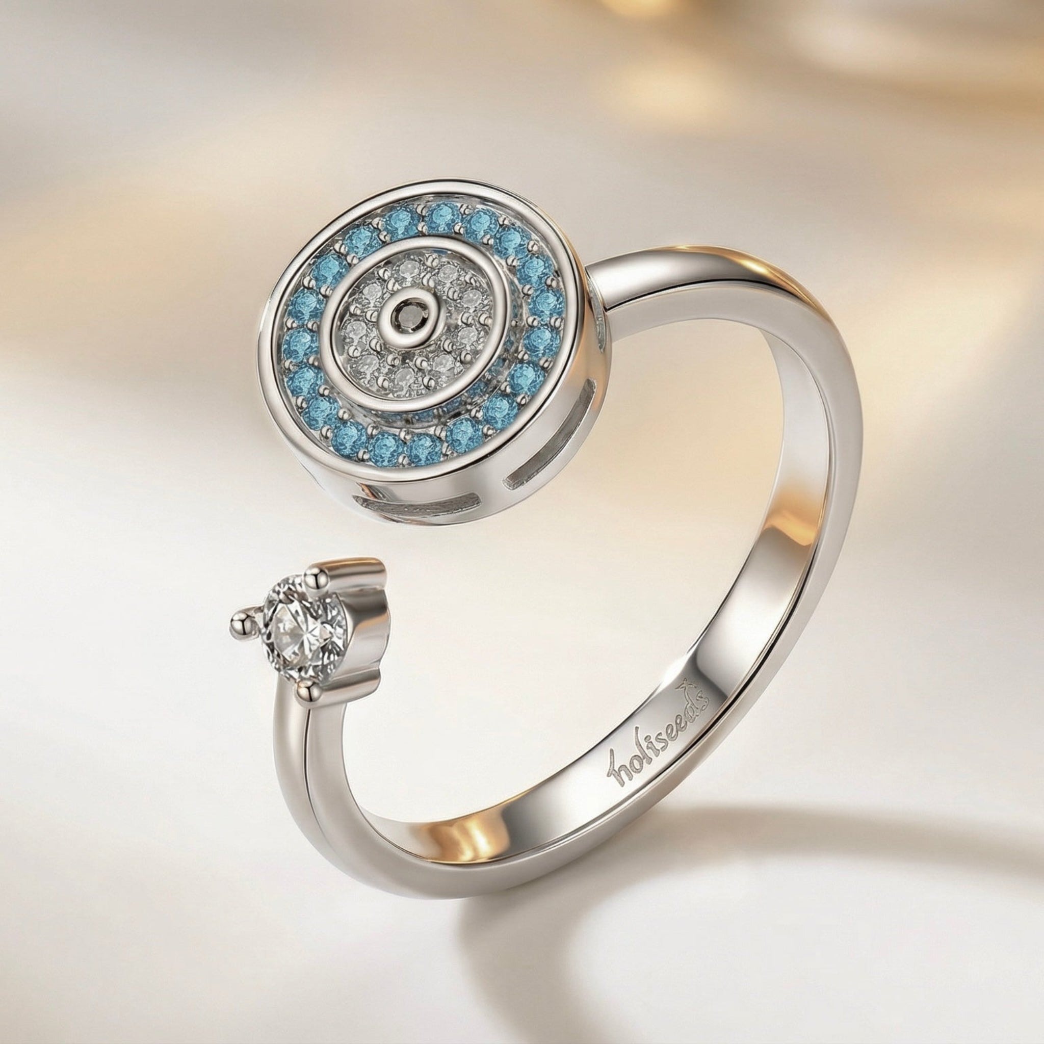 Bague argentée Onde Azur Holiseeds au design circulaire avec pierres bleues, présentation élégante.